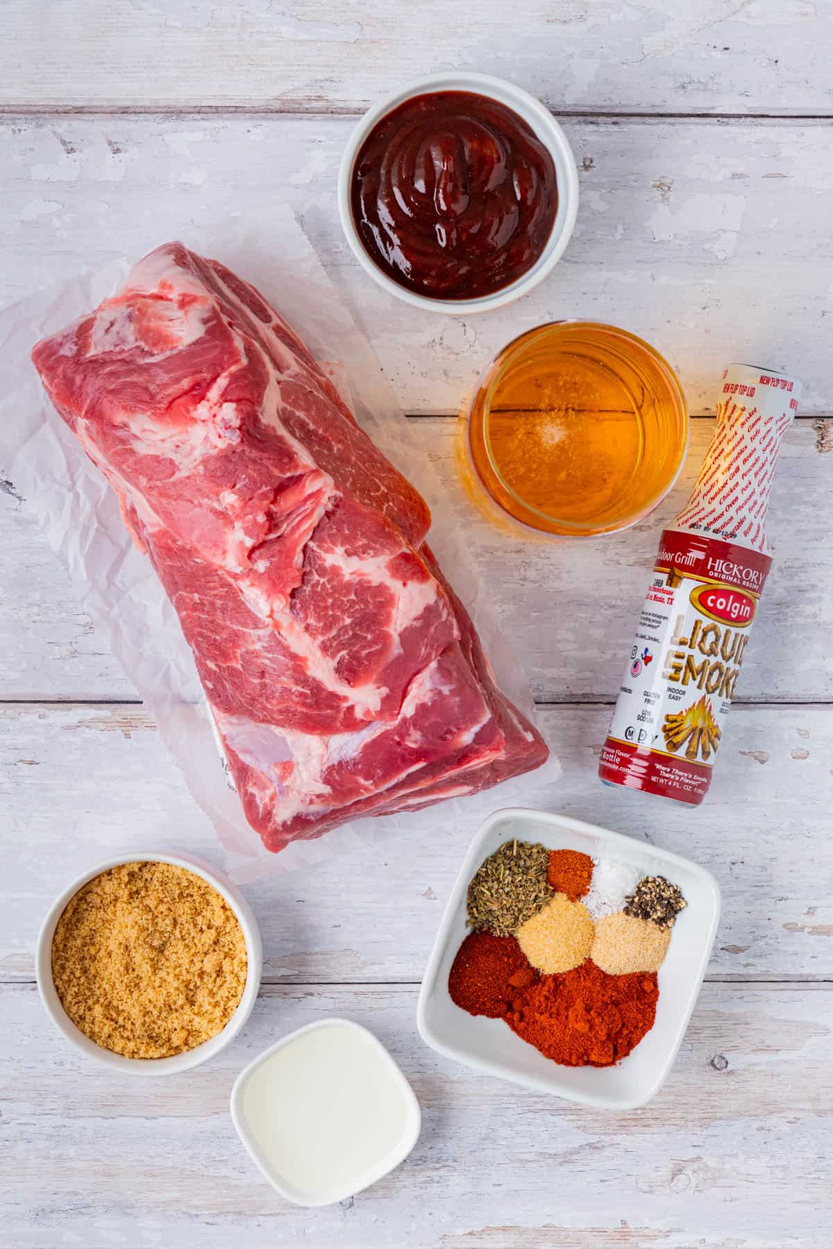 Ingredients for Crockpot BBQ Pulled Pork: BBQ Sauce, Beer, Spices, Sugar, Pork Shoulder, A bottle of Liquid Smoke.