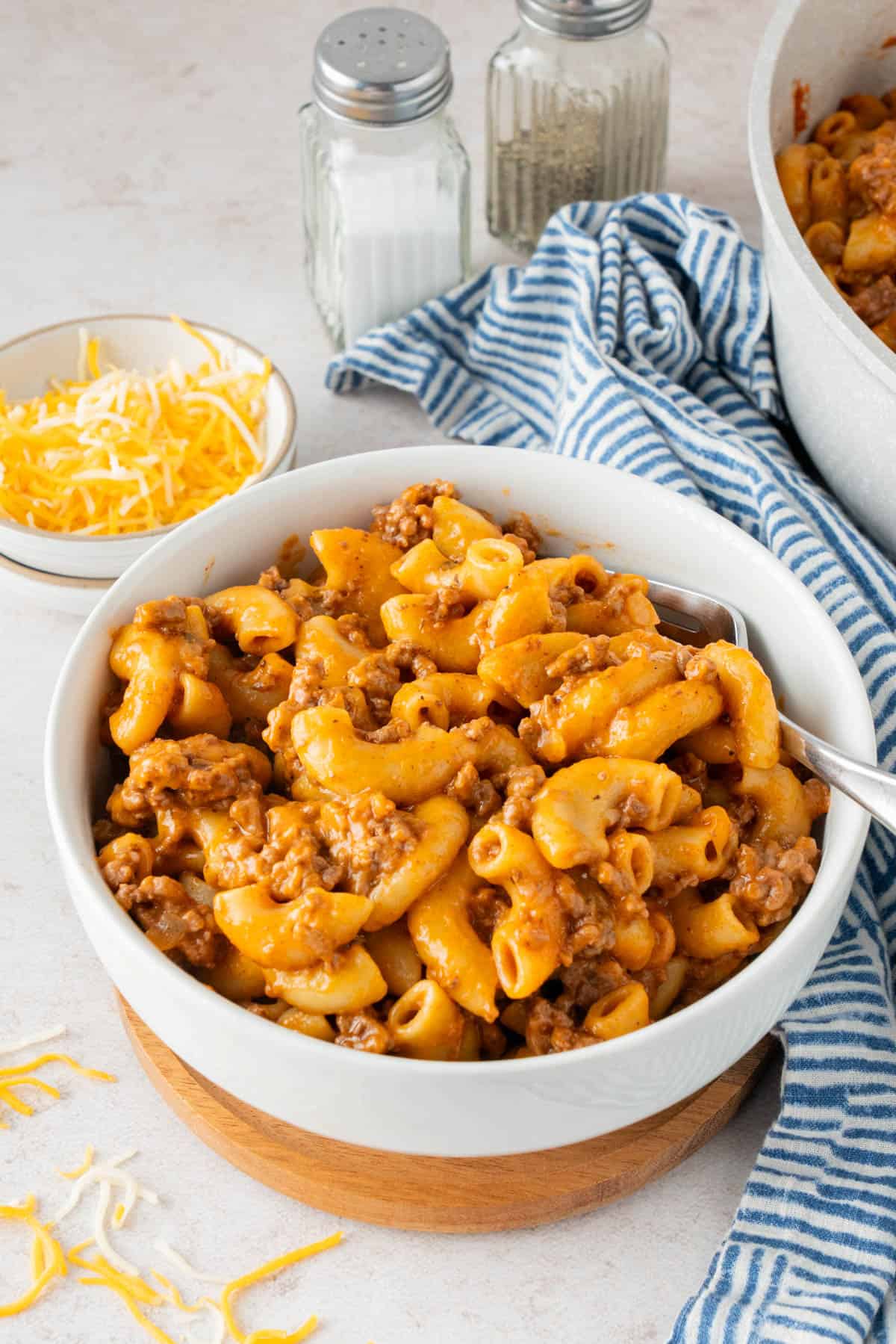 Hamburger helper served in a white bowl with a fork. 