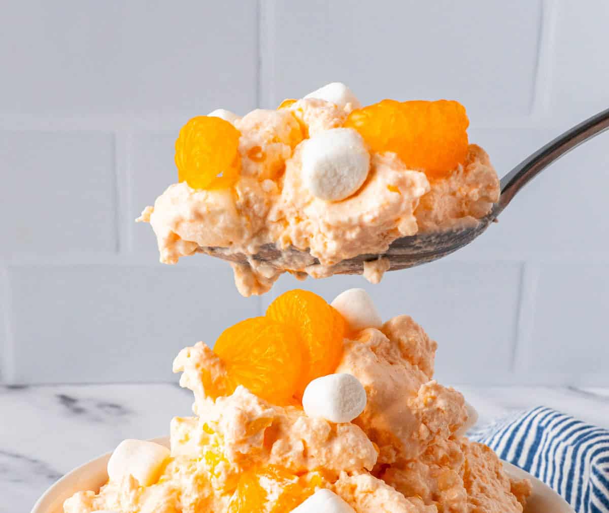 A close up spoonful of Creamsicle Orange Fluff Jello Salad