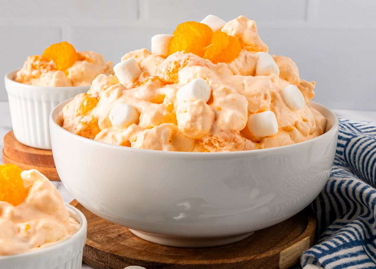A big bowl of Creamsicle Orange Fluff Jello Salad and some on the dessert bowls