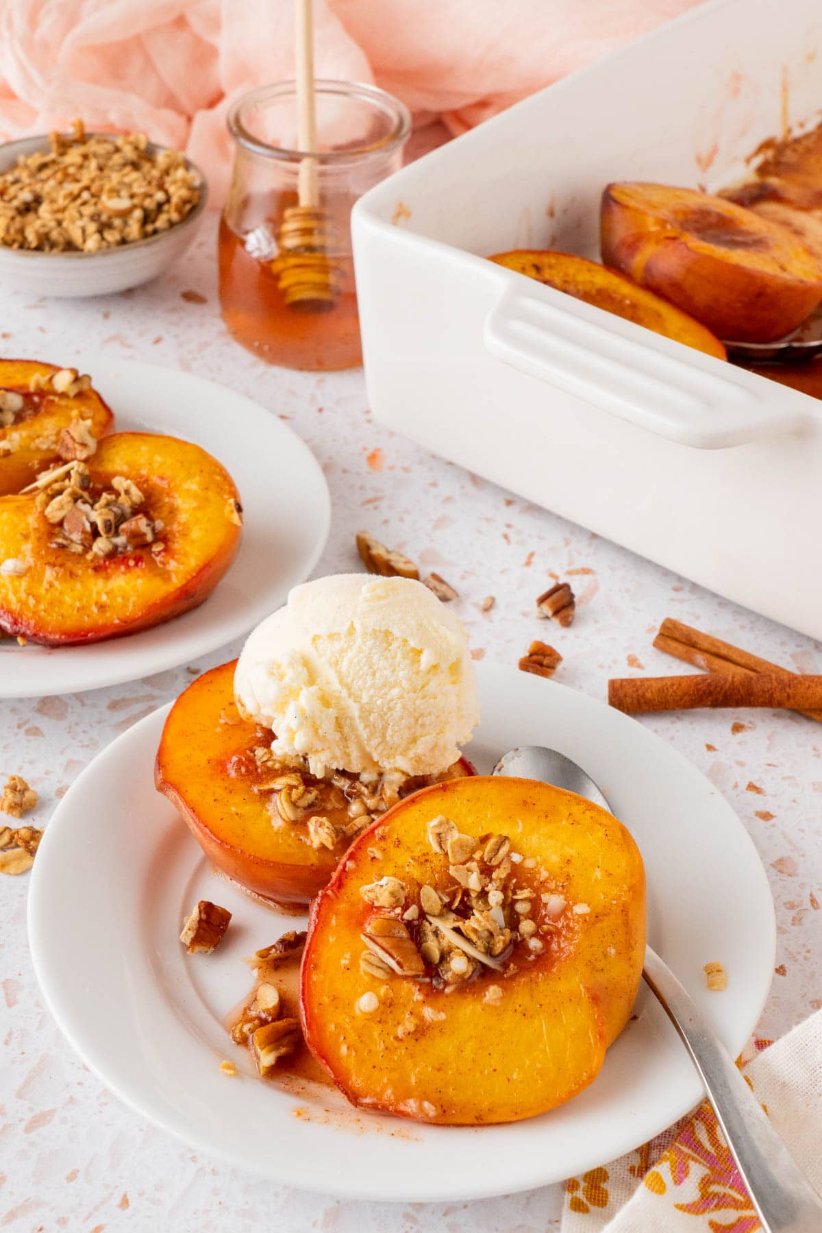 A serving of Honey Roasted Peaches (Oven Baked Peaches) with a scoop of vanilla ice cream/