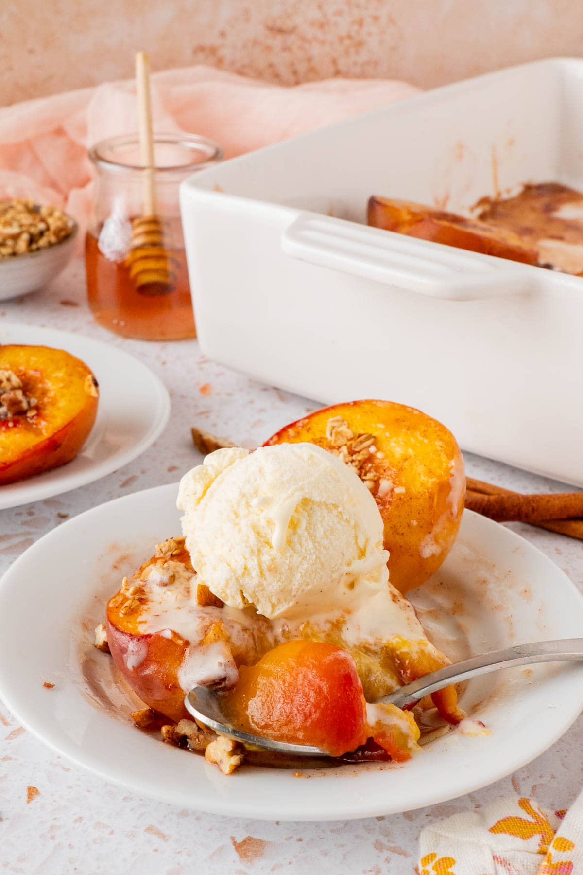 a spoonful from the serving of Honey Roasted Peaches (Oven Baked Peaches) with the vanilla ice cream