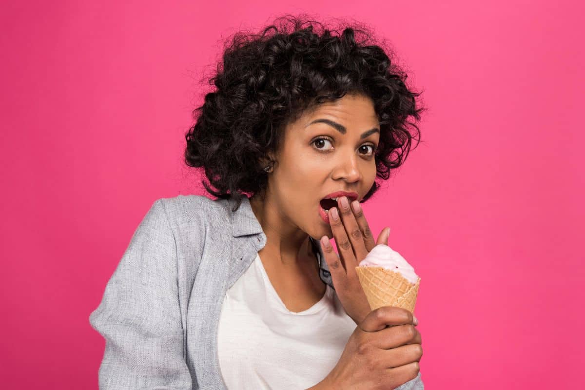 woman surprised eating ice cream cone -