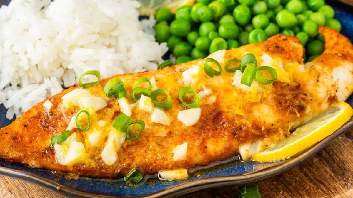 A serving of Air-Fried Tilapia with white rice and green peas.