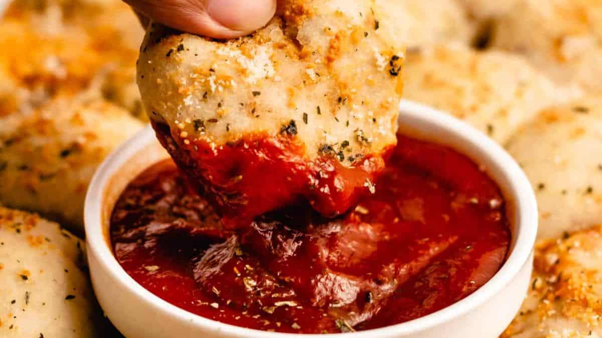 A serving of Pizza Poppers dipped in marinara. 