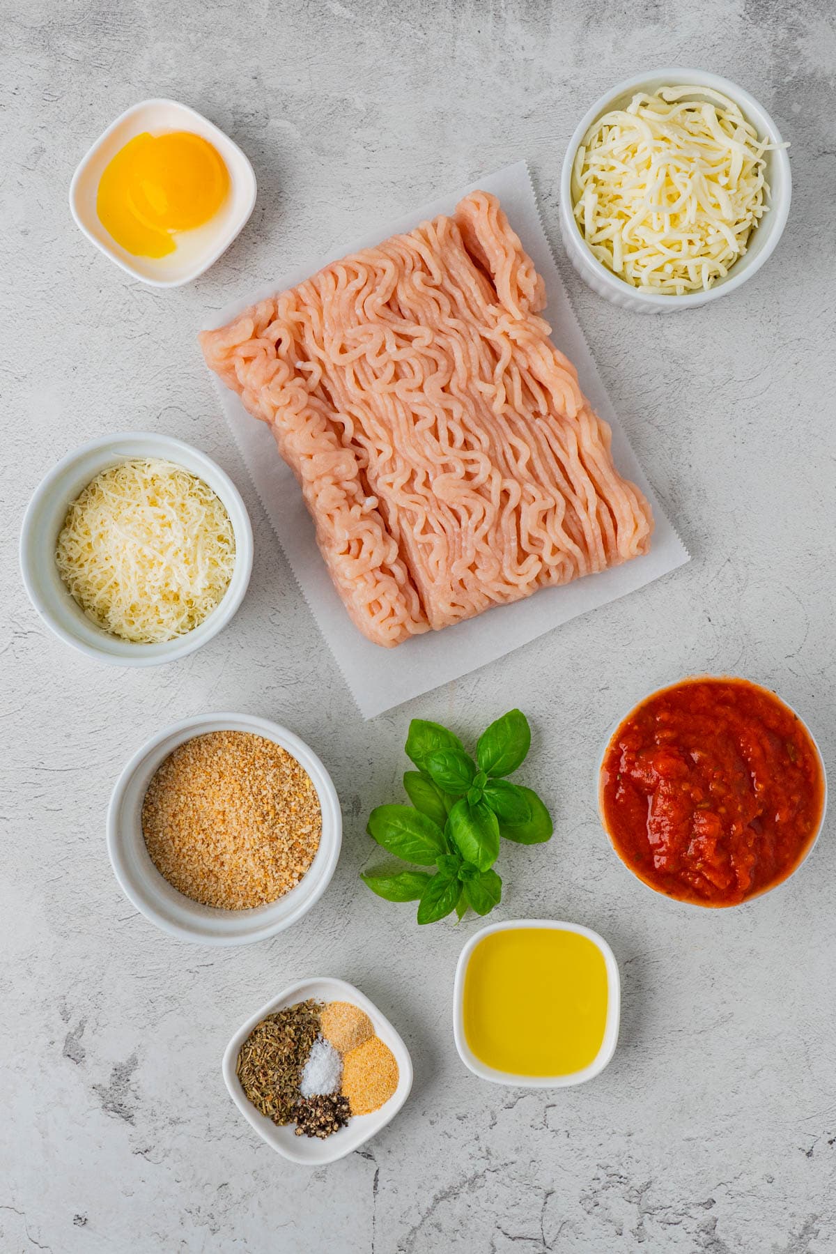 Cheesy Chicken and Rice Casserole ingredients: ground chicken, Mozzarella cheese, Parmesan Cheese, panko, marinara sauce. basil. seasonings, olive oil.