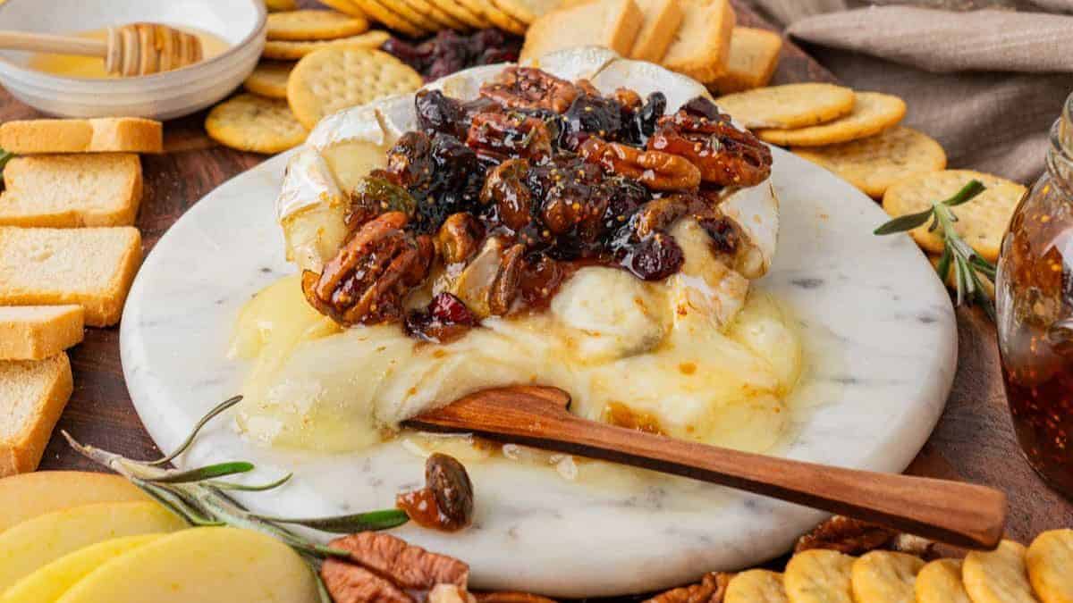 A serving of Baked Brie with Jam on a marble plate.