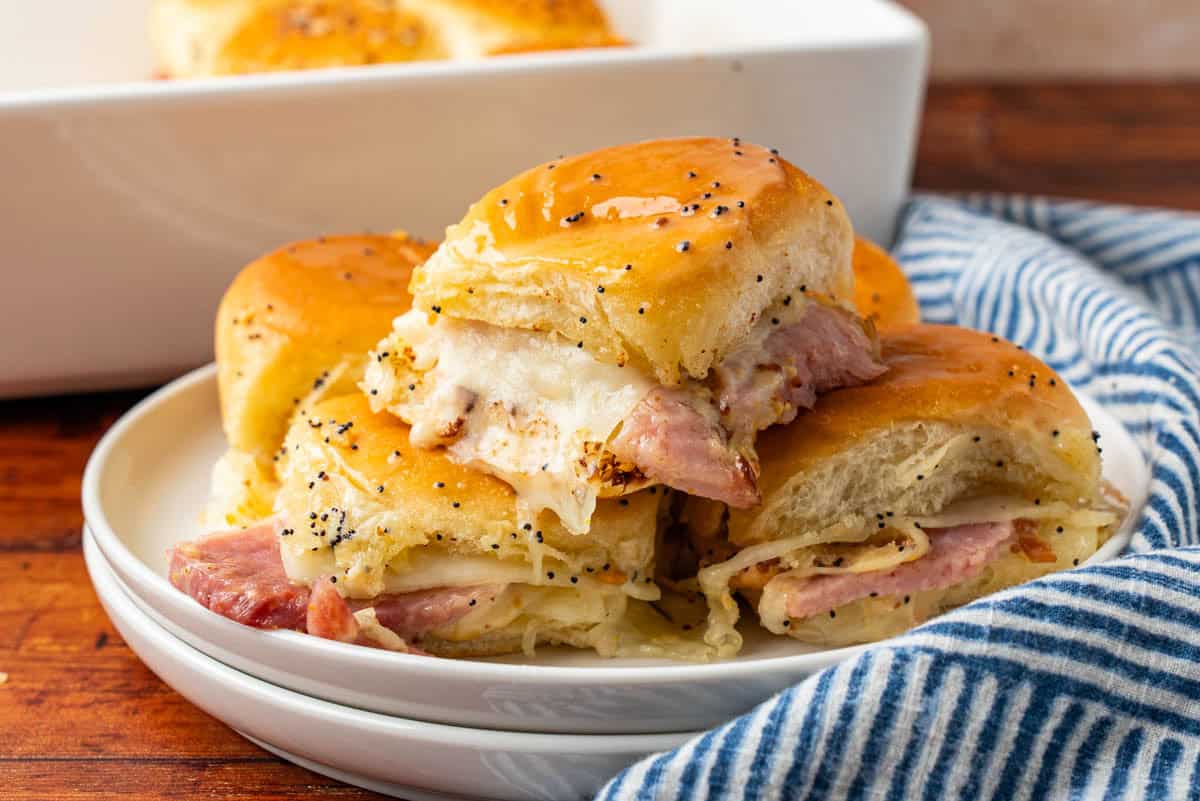 A white plate with Ham And Cheese Sliders on Hawaiian Rolls