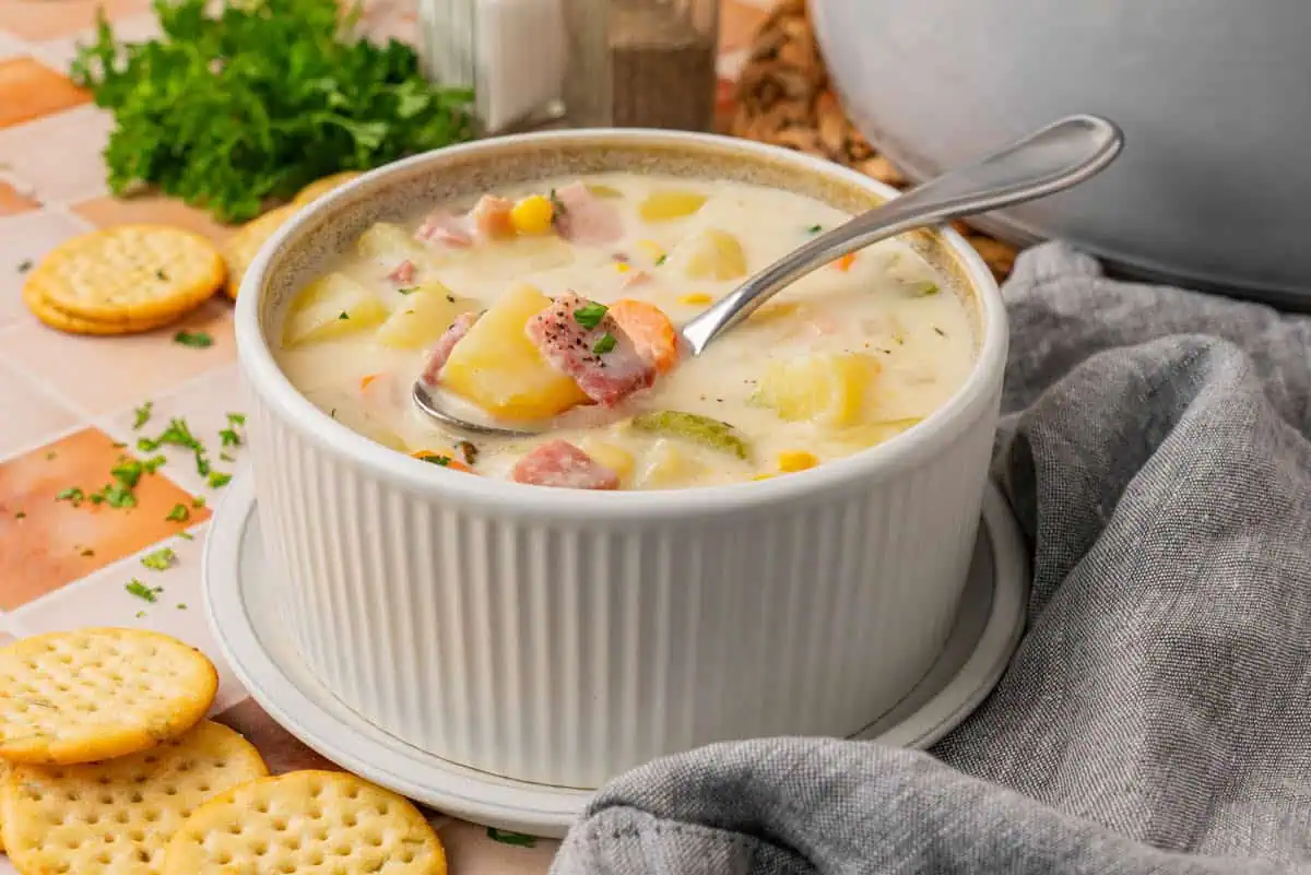 A bowl of Creamy Ham And Potato Soup with a spoon.