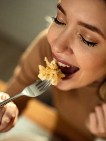 happy woman eating pasta