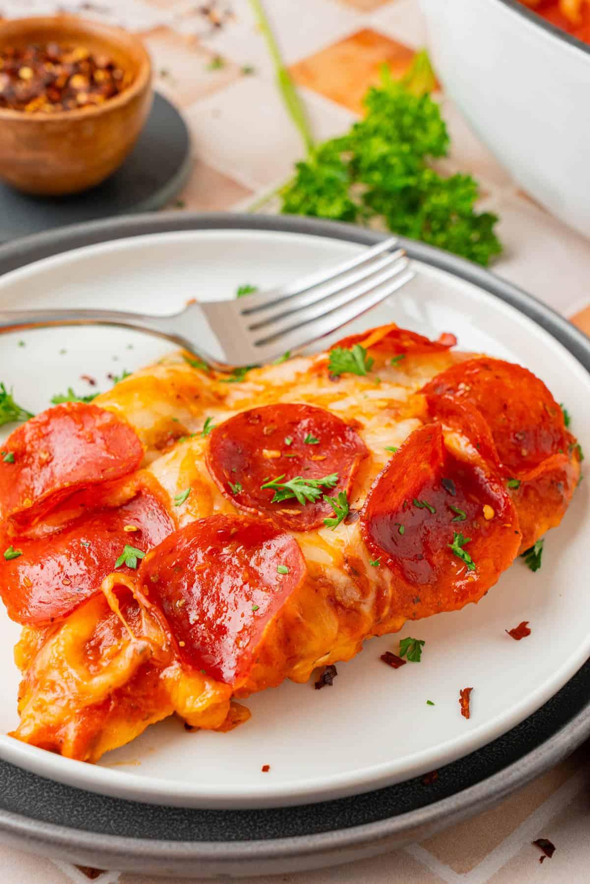 A serving of Low Carb Pizza Chicken on a plate with a fork. 
