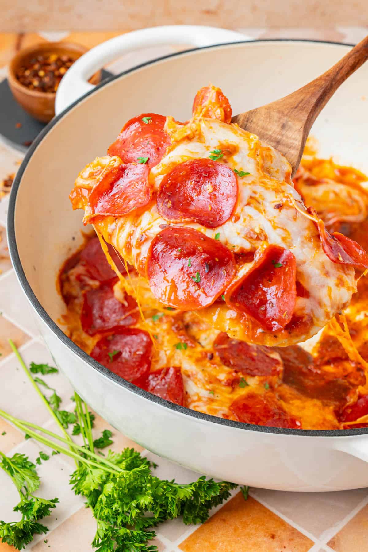 A serving of Low Carb Pizza Chicken scooped by a wooden spatula.