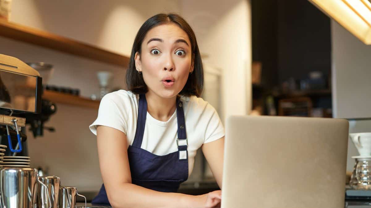 surprised woman looking surprised at the computer in the kitchen
