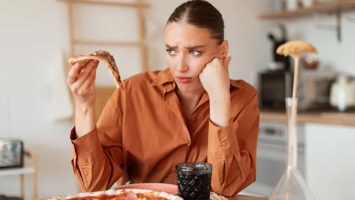 unhappy woman looking at pizza