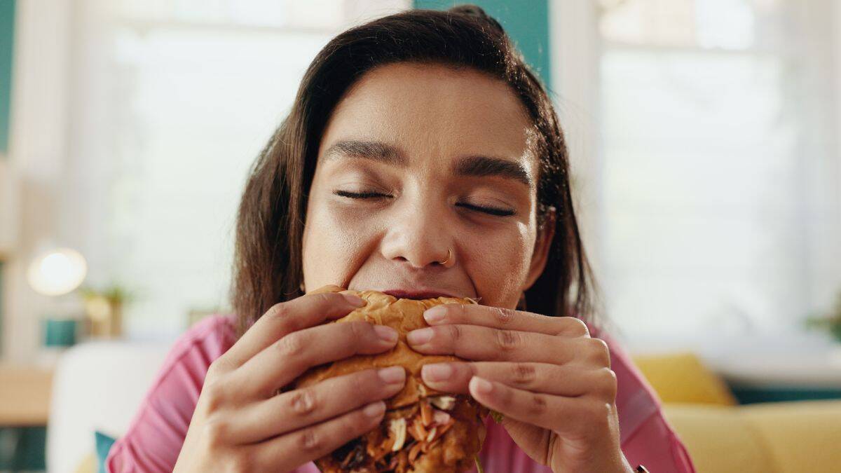 woman eating messy sandwich