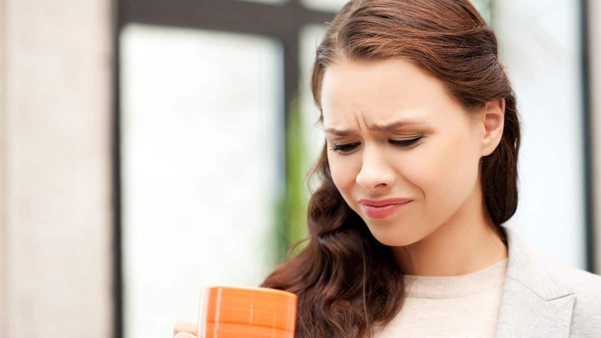 woman looking disgusted with drink