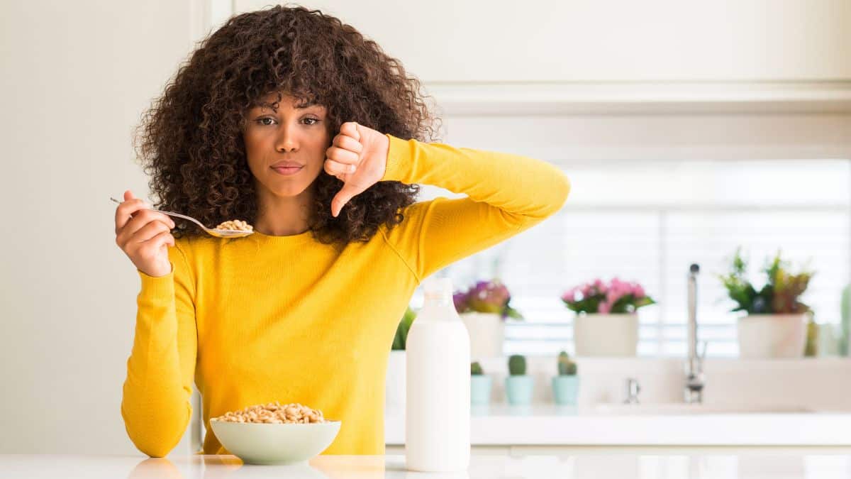 woman with cereal and thumbs down