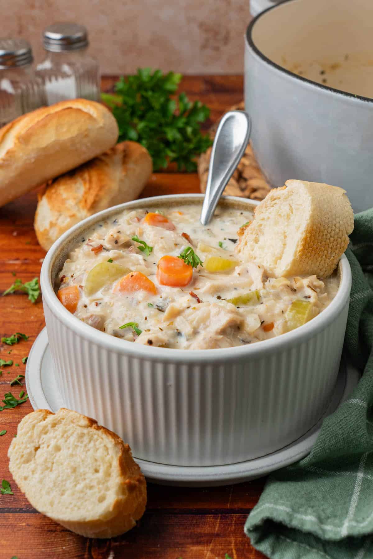 finished photo of the bowl of soup, complete with a spoon and a piece of bread dunked