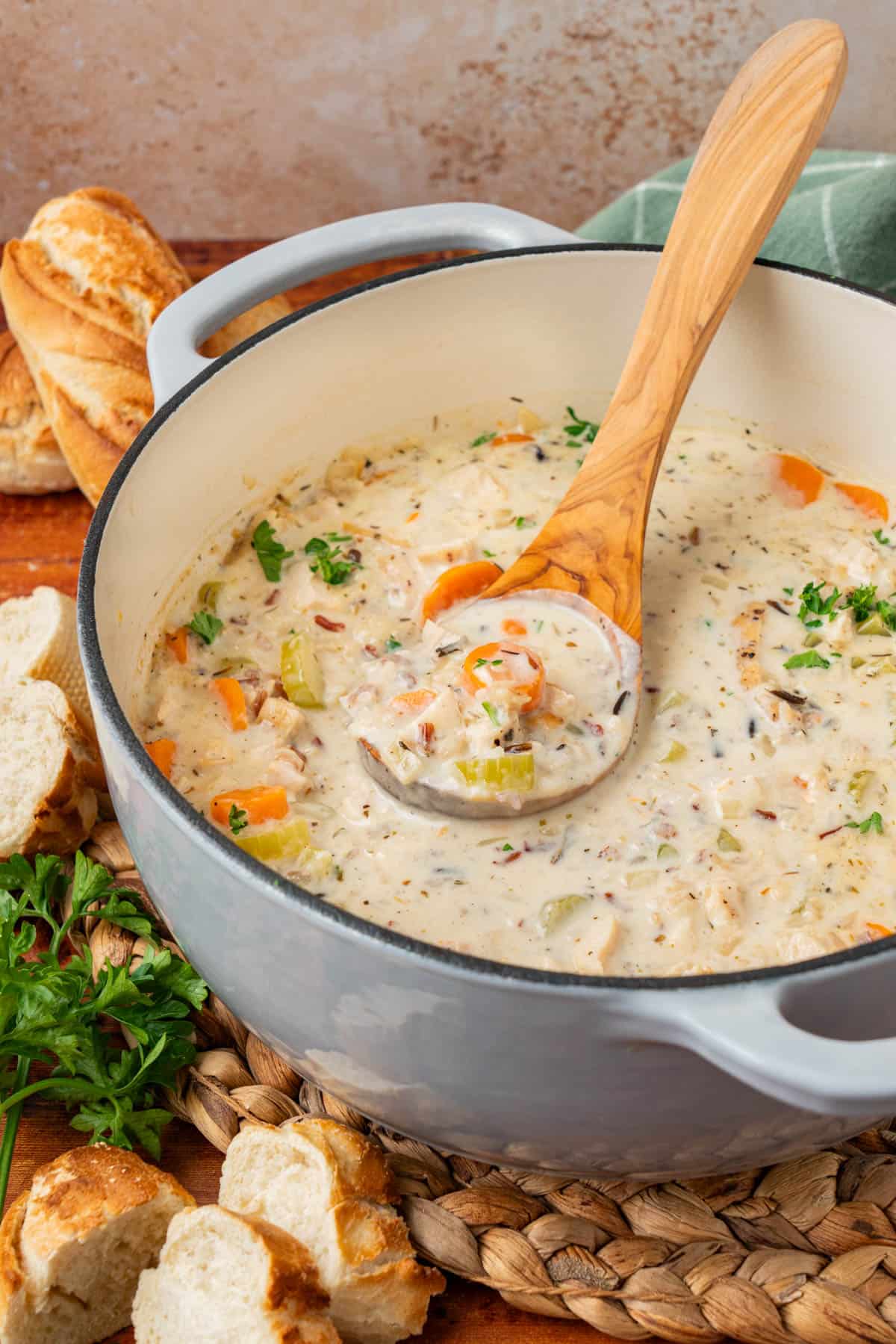 side shot of the pot of soup, with a wooden ladle 