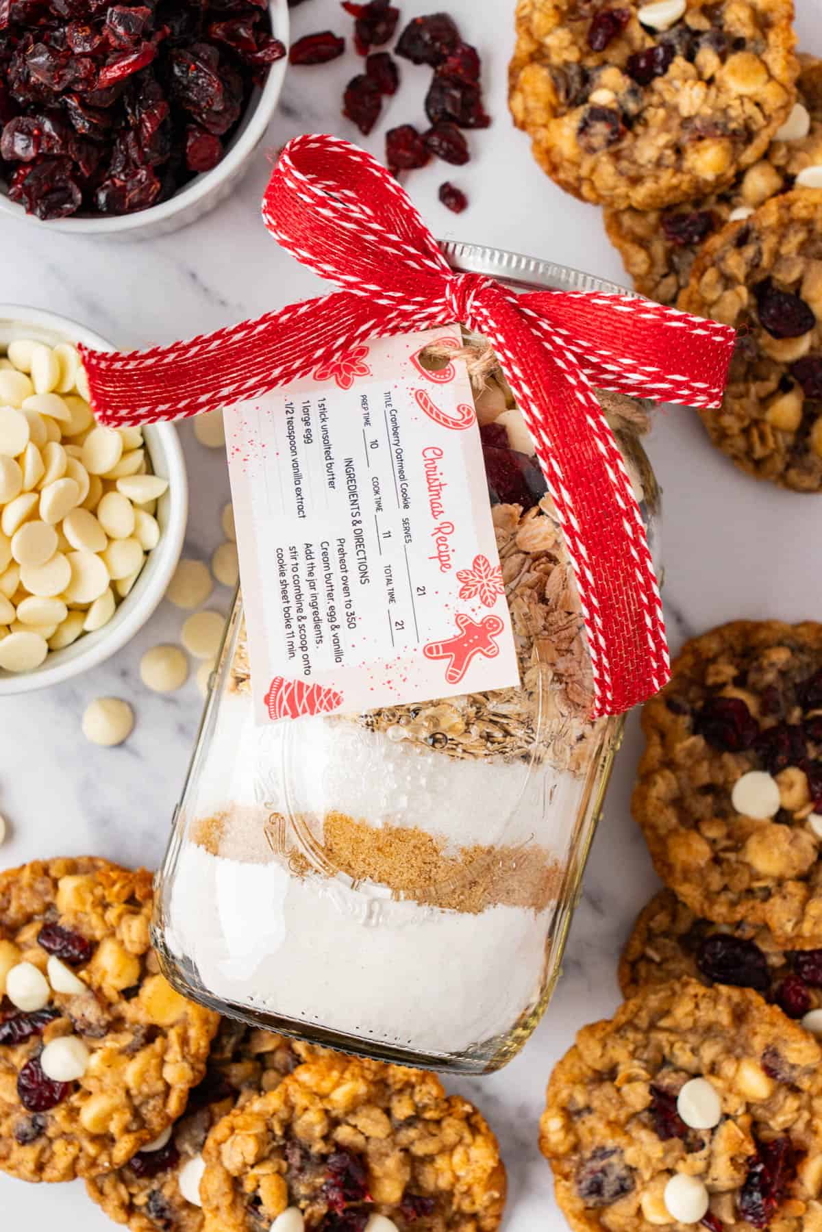 the jar decorated mason jar laying on a counter with the baked cookies