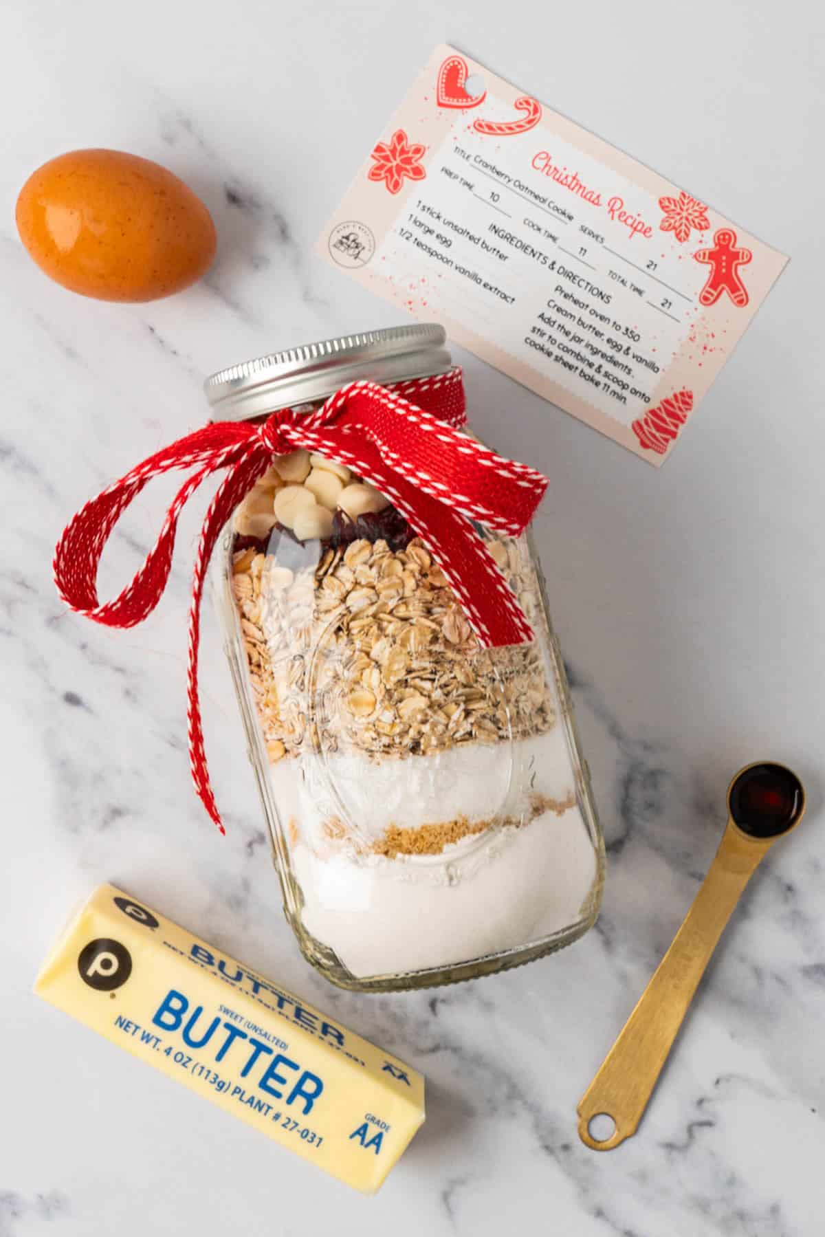 the ingredients needed to bake the cookies are a stick of butter, vanilla extract, an egg and the mason jar with the dry ingredients