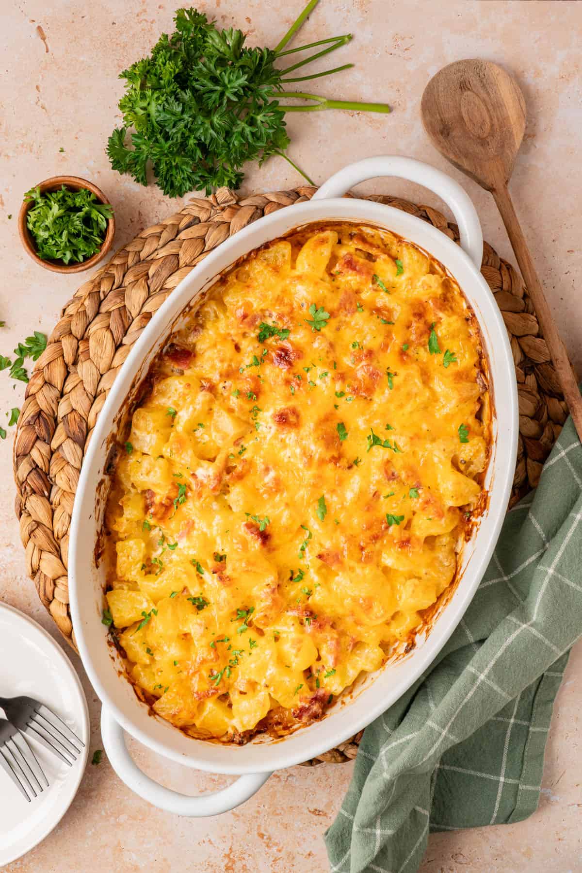 A white casserole dish with ham and potato casserole and cheese melted on top
