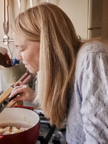 happy woman smelling stew at home
