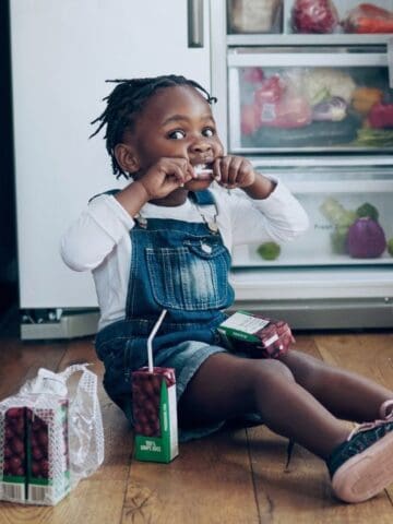 little girl eating from the fridge