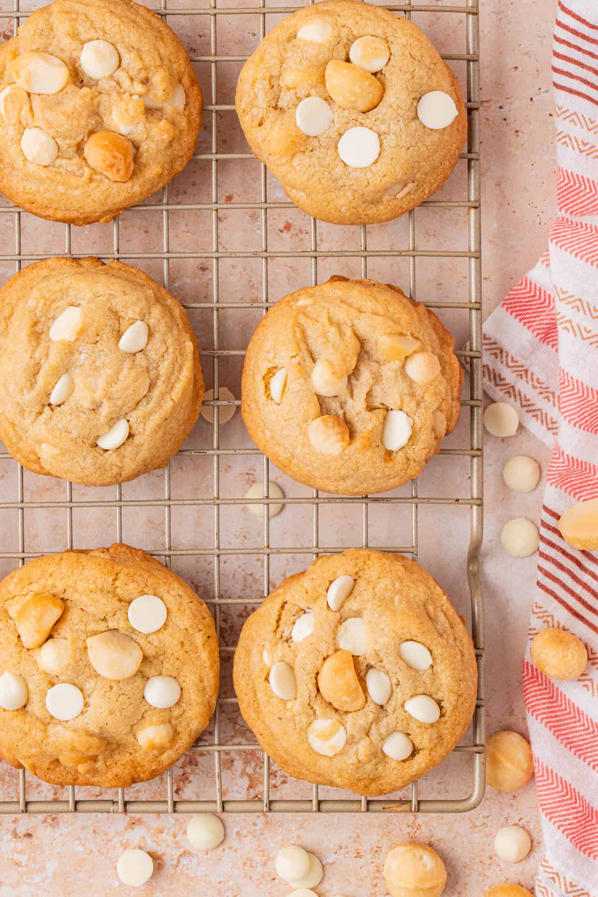 Brown butter macadamia nut cooies on a wire rack, overhead shot.