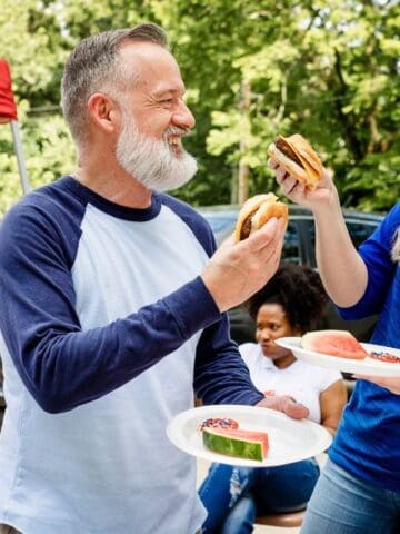 man and woman tailgating with burgers