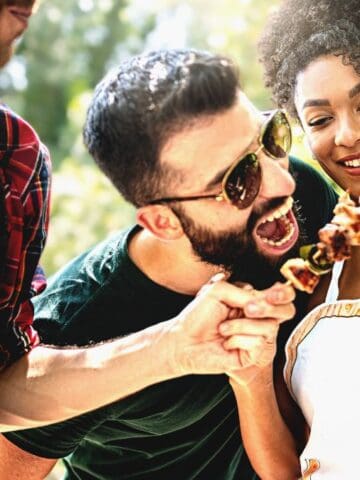 man and woman with beef skewer