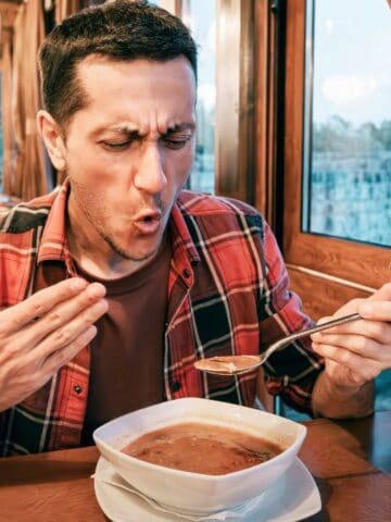 man eating spicy soup