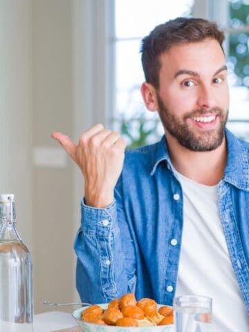 man showing thumbs up with spaghetti and meatballs