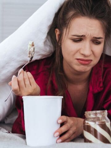 upset woman with food in bed