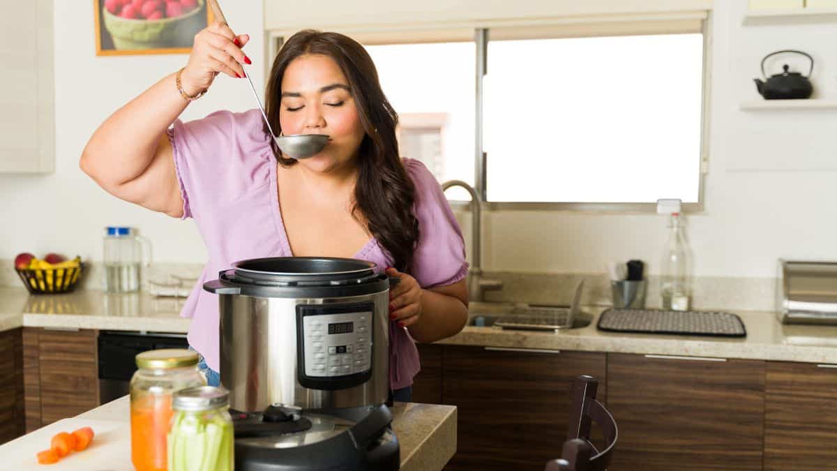 woman drinking from ladle with slow cooker
