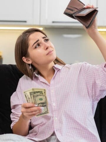 woman looking at wallet in kitchen