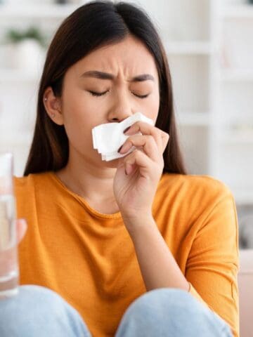 woman looking sick with water and tissue