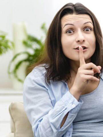 woman showing shhh with pizza