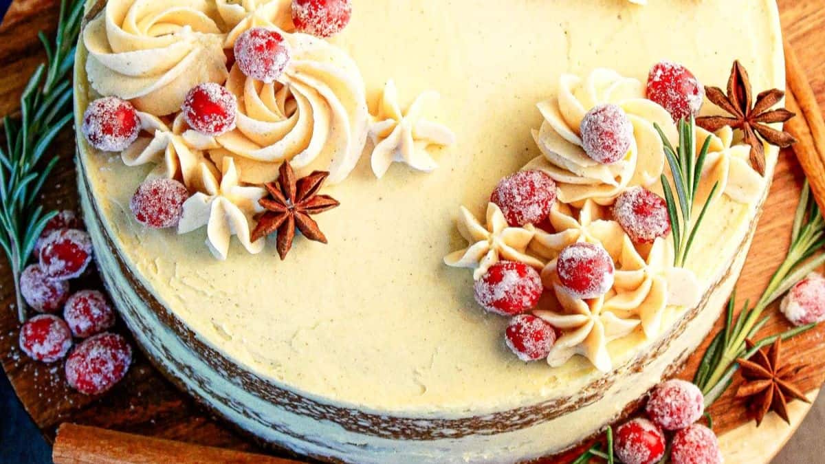 A top shot of the festive spice cake that shows the toppings and completed swirls of cream icing.