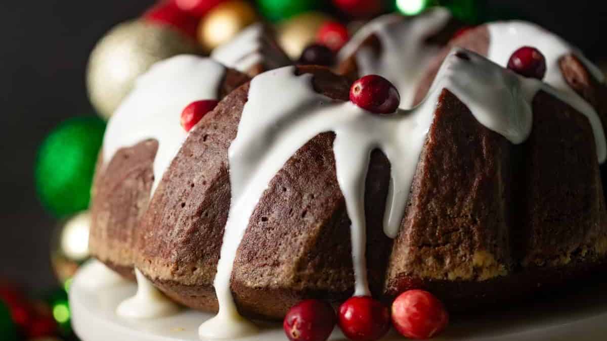 A close-up shot of Gingerbread Bundt Cake with Cream Cheese Frosting while resting on a cake stand. 