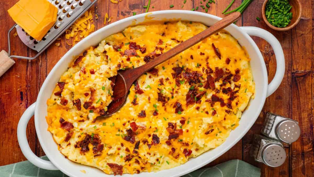 A top shot of Mashed Potato Casserole served in a white oblong casserole dish. 