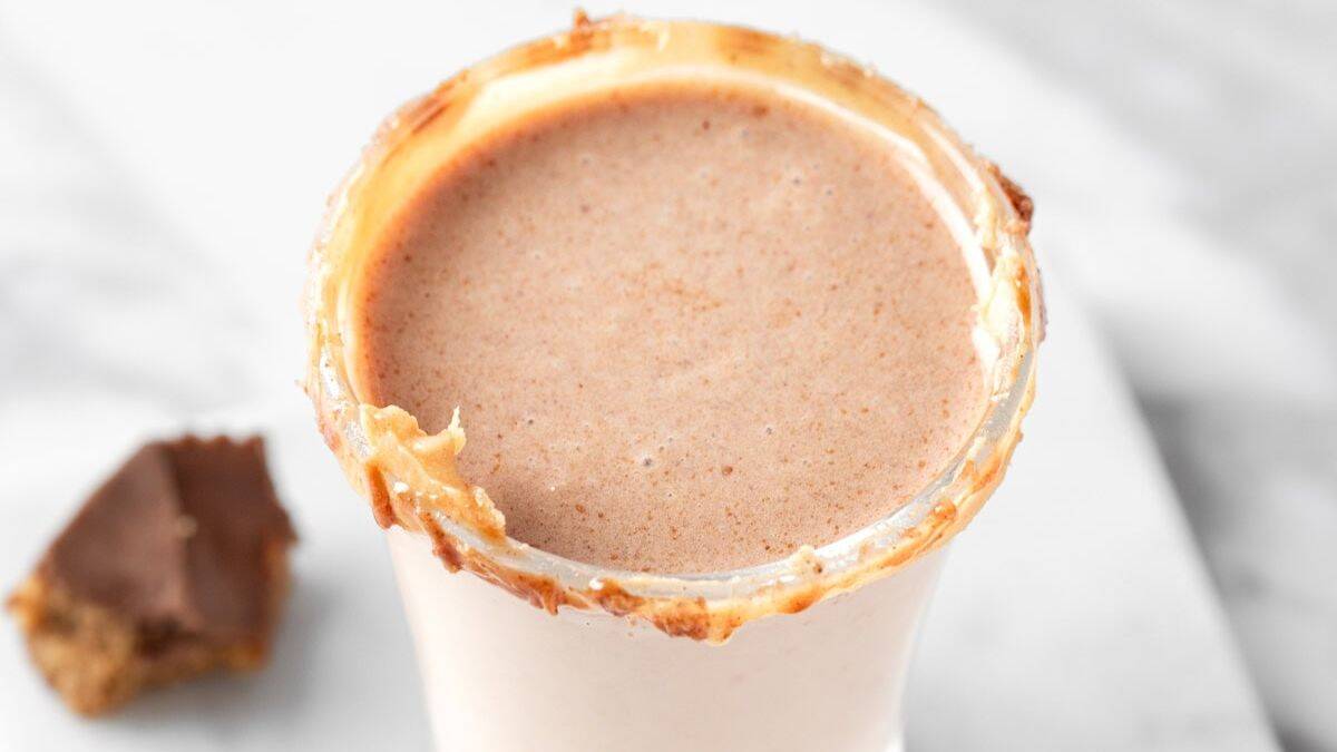 A close-up shot of Peanut Butter Cup Shot served in a clear shot glass. 