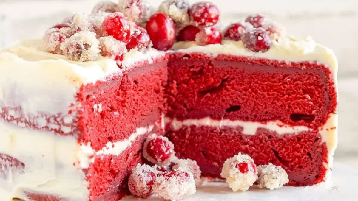 A shot showing the inside layers of the red velvet cake from its cut side, complete with cream cheese frosting and some toppings.