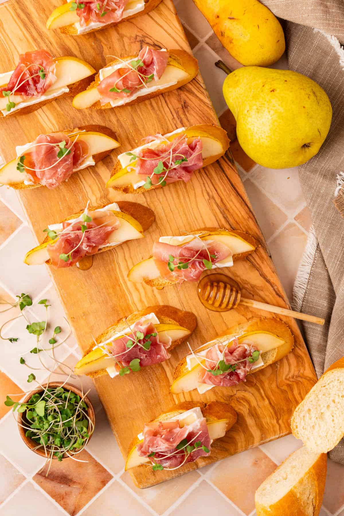 The Brie Crostini arranged on a wooden board, fully garnished and ready to serve.