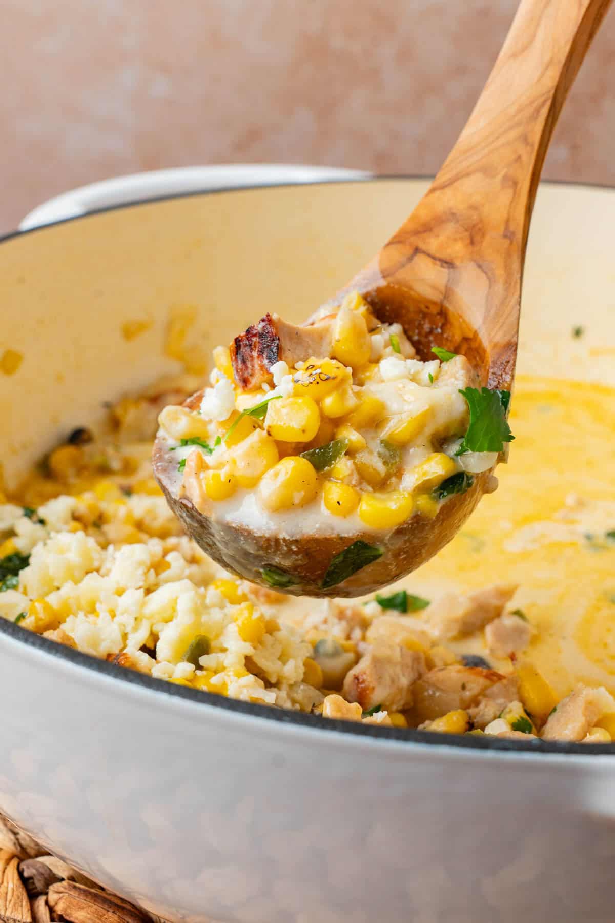 A wooden ladle full of the street corn soup