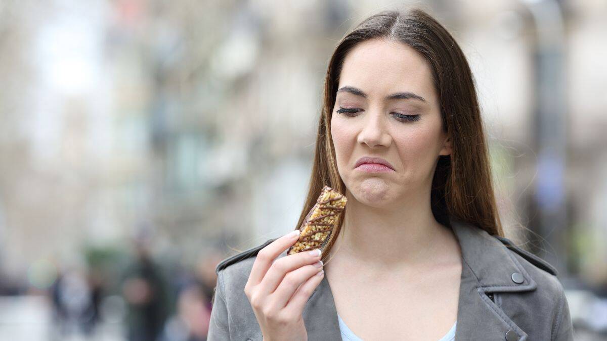 woman looking at protein bar