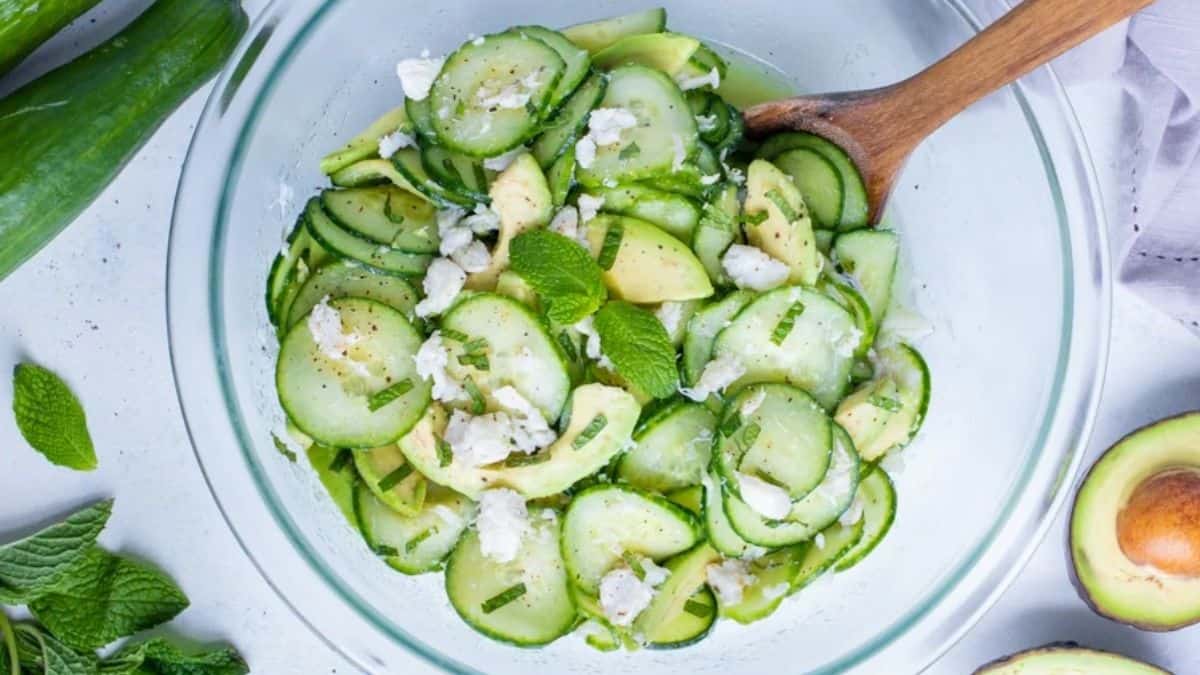 A top shot view of a clear serving bowl filled with Cucumber Avocado Crab Salad.