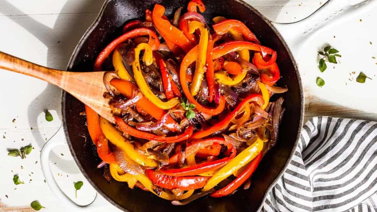Fajita Veggies on a pot with a wooden spoon.