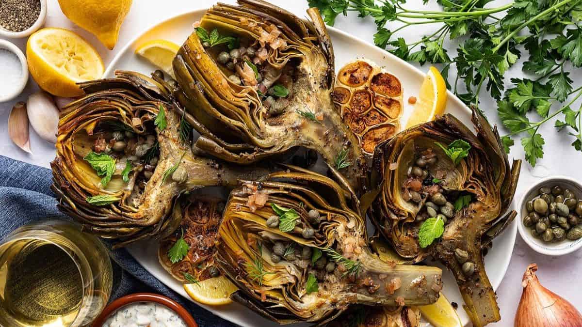 A serving plate with roasted artichokes.