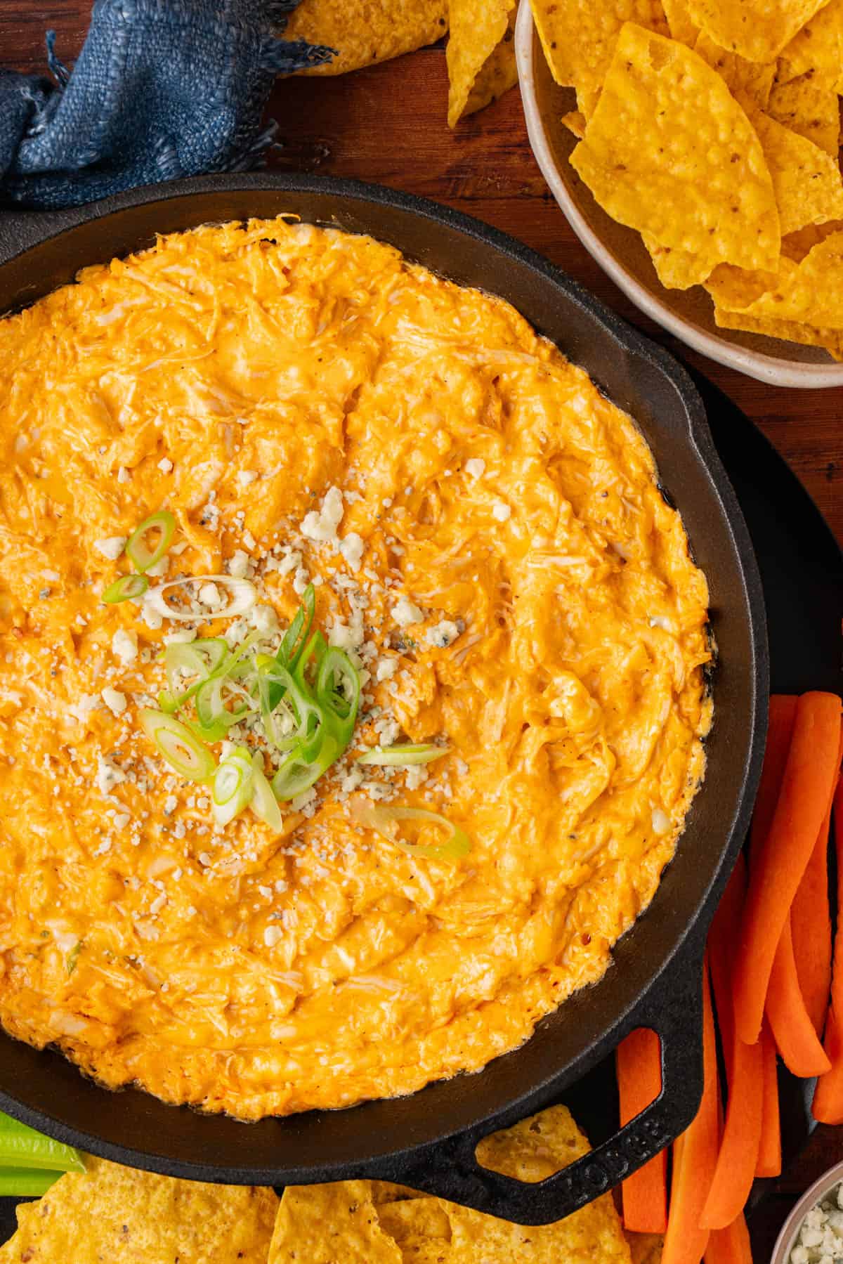 Closer shot of buffalo chicken dip garnished with green onions.